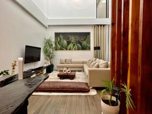 sala de estar con sofá y TV en Tranquil Villa - Siargao en General Luna
