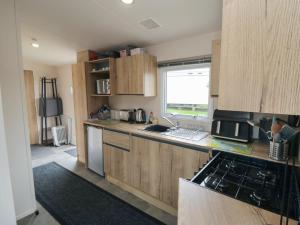 a kitchen with wooden cabinets and a counter top at No30 Elm Rise in Filey