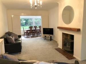 een woonkamer met een open haard en een televisie bij Surrey - Private House with Garden & Parking 12 in Wentworth