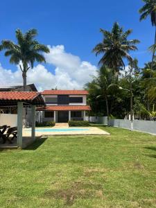 ein Haus mit einem Pool und Palmen in der Unterkunft CASA DE PRAIA PEROBA in Maragogi