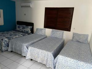 2 Betten und ein Sofa in einem Zimmer in der Unterkunft CASA DE PRAIA PEROBA in Maragogi
