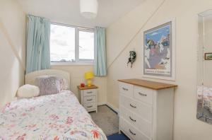 a bedroom with a bed and a dresser and a window at Ann's Place in York