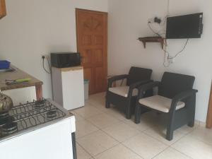 a kitchen with two chairs and a stove at Palmont Commercial Self-Catering Apartments - Beau Vallon in Beau Vallon