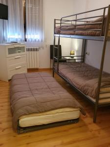 a bedroom with two bunk beds and a television at Apartamentos Grifo Vacances Julia in El Tarter