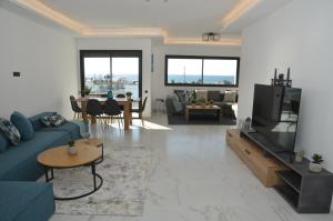 un soggiorno con divano blu e TV di Fabulous sea view apartment a El Harhoura