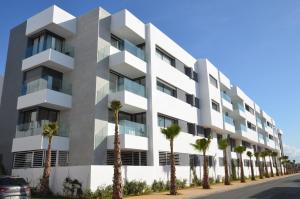 un edificio con palme di fronte ad esso di Fabulous sea view apartment a El Harhoura