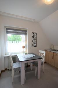 a table and chairs in a kitchen with a window at Nord-Strand in Norden