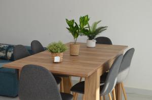 un tavolo in legno con sedie e piante sopra di Fabulous sea view apartment a El Harhoura