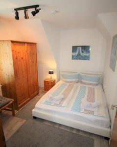 a bedroom with a large white bed in a room at Nord-Strand in Norden +3 photos