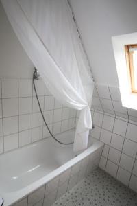 a bath tub with a shower curtain in a bathroom at Nord-Strand in Norden