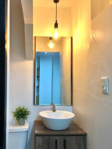 a bathroom with a sink and a mirror and a toilet at HOTEL PLAYAS PERDERNALES ECUADOR in Pedernales