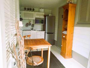 una pequeña cocina con mesa y nevera en Les Gîtes de Bergette, en Petit-Bourg