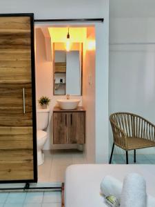 a bathroom with a sink and a toilet and a mirror at HOTEL PLAYAS PERDERNALES ECUADOR in Pedernales