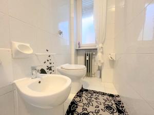 トリノにあるTrilocale con parcheggio privato Arena Inalpi, PalaTazzoli, Palavela Lingotto, "Exclusive Suite " La casa di Bertino "の洗面台とトイレを備えた白いバスルーム +26枚の写真