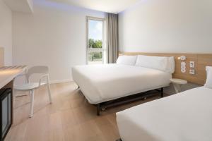 a hotel room with a bed and a table at B&B HOTEL Lleida in Lleida