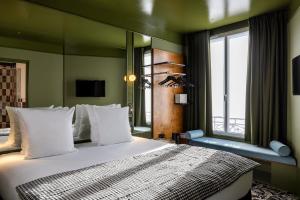 a bedroom with a large bed and a window at Hôtel La Conversation in Paris