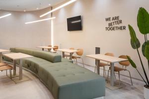 - une salle d'attente avec des tables et un canapé dans l'établissement B&B HOTEL Lleida, à Lleida