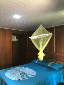 a bed with a net on top of it at Ipanema Lodge in Careiro