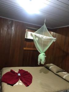 a bed with a net on top of it at Ipanema Lodge in Careiro