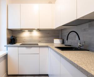 una cucina con mobili bianchi e un lavandino di Art Apartament Chmielna 10 a Varsavia