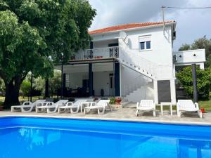 a villa with a swimming pool in front of a house at Apartment 877-1 in Bibinje