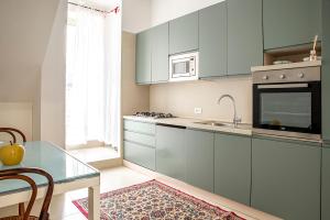 a kitchen with blue cabinets and a glass table at Mazzini 5 in Ragusa +18 photos