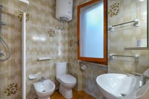 une salle de bain avec toilettes, lavabo et miroir dans l'établissement Casa Elba, à Procchio 14 autres photos