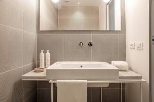 uma casa de banho com um lavatório branco e um espelho. em Mazzini 5 em Ragusa