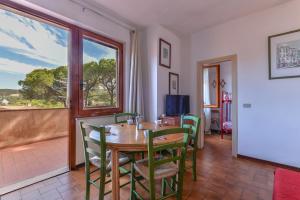 une salle à manger avec une table et des chaises et une fenêtre dans l'établissement Casa Elba, à Procchio