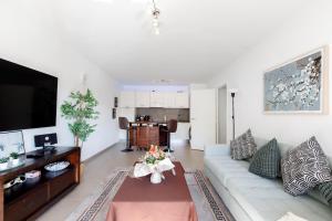a living room with a couch and a table at Lovely 2 bedroom condo with pool in Vallauris
