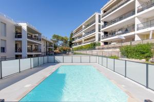 una piscina frente a un edificio de apartamentos en Lovely 2 bedroom condo with pool, en Vallauris