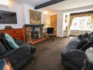 a living room with two couches and a fireplace at Chapel House in Brough