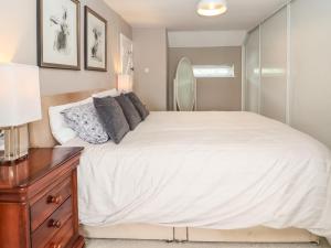 a bedroom with a large white bed and a dresser at Chapel House in Brough