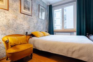 una camera da letto con un letto e una sedia di Art Apartament Chmielna 10 a Varsavia