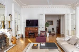 uma sala de estar com um sofá e uma lareira em Prestigious Appartement Trocadero em Paris