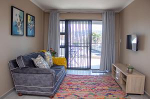 约翰内斯堡Airville Luxury Apartments, 7min Drive to Cresta Mall的带椅子和滑动玻璃门的客厅 更多37张照片