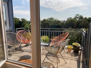 un balcón con 2 sillas y una ventana con vistas. en Mango Living - Stadtoase in Mönchengladbach, 95 qm, spacious, 3 Schlafzimmer, Nähe Hauptbahnhof, en Mönchengladbach