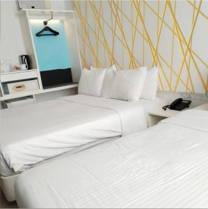 two white beds in a room with a television at Room in Genting Highland in Genting Highlands