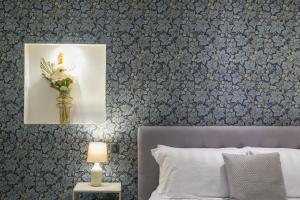 ein Schlafzimmer mit einem Bett mit blauer Blumentapete in der Unterkunft The Notting Hill Residence - 2 BR Apartment Close to Hyde Park in London