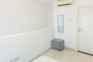Dieses weiße Zimmer verfügt über einen Spiegel und einen Schrank. in der Unterkunft Skyline 1 Bed, Loft 2 @Embassy Gardens in Cantonments
