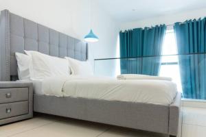 Schlafzimmer mit einem großen Bett und blauen Vorhängen in der Unterkunft Skyline 1 Bed, Loft 2 @Embassy Gardens in Cantonments