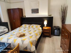 sypialnia z łóżkiem z żółto-białą kołdrą w obiekcie St Lucia lodge Leicester long stays available w mieście Leicester