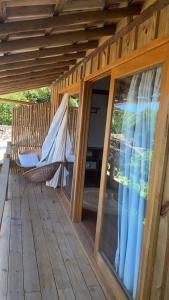 a porch with a hammock on a wooden deck at Pausa Trancoso in Trancoso