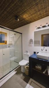 a bathroom with a shower and a toilet and a sink at Pausa Trancoso in Trancoso