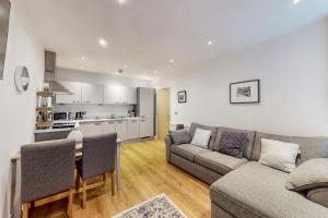 sala de estar con sofá, mesa y cocina en Bright & beautiful 1 bedroom flat in London Bridge, en Londres