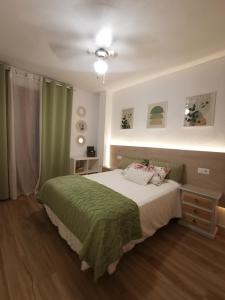a bedroom with a bed with a green blanket at Costamar bungalow familiar, piscina y terraza, a 5 min de la playa in Arenales del Sol +28 photos