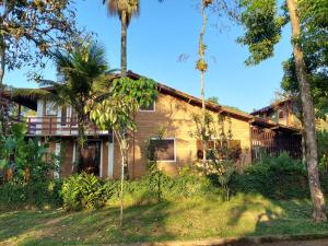 ein Haus mit Palmen davor in der Unterkunft Casa Rústica Alemã - 50m da praia in Ubatuba