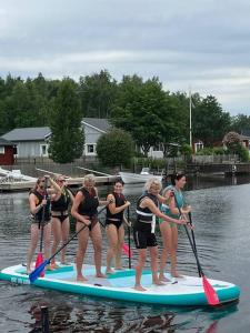 a group of women on a paddle board in the water at Lägenhet med sjötomt. Vildmark i tätort. in Umeå