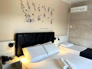 1 dormitorio con 1 cama con cabecero negro en Pousada Villa Atlântica, en Balneário Camboriú