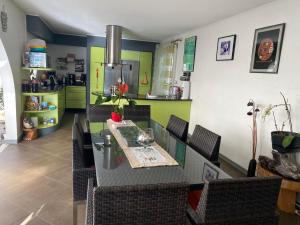 una sala da pranzo con tavolo e sedie e una cucina di Ti Kaz Lo Ker chambre d'hôte chez l'habitant a Saint-Joseph